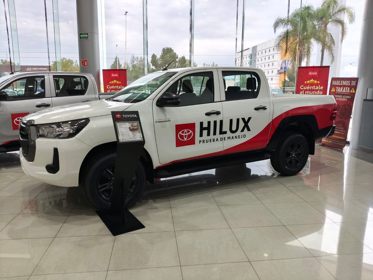 White and red Toyota Hilux pickup truck on display in a showroom
