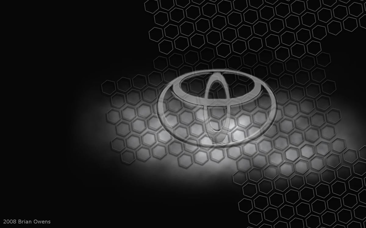 Sleek silver metallic UFO with glowing underside hovering above hexagonal honeycomb pattern on black background