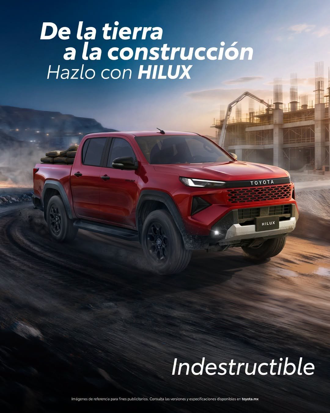 Red Toyota Hilux pickup truck driving on dirt terrain with construction site and buildings in background, Spanish promotional text overlay
